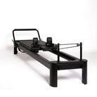 Pilates reformer aluminium total black, vue de trois quarts côté poulies